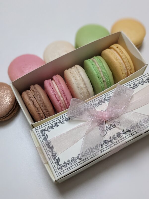 Packaged box of 5 macarons with a pink ribbon